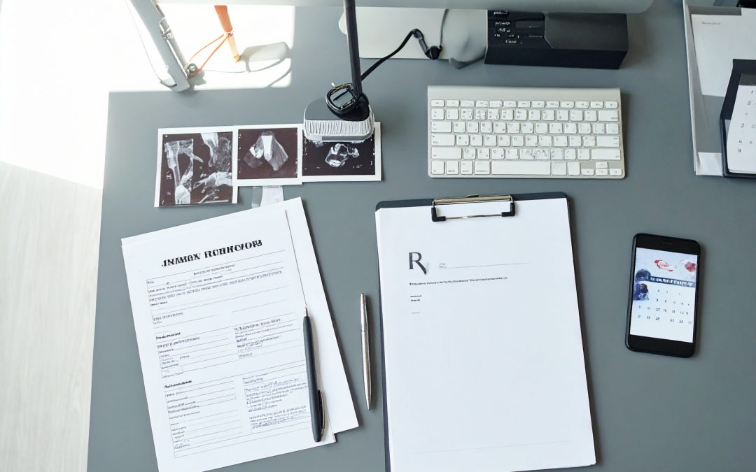 Injury documentation: Medical records, x-rays, forms, & phone showing calendar appointment on desk.